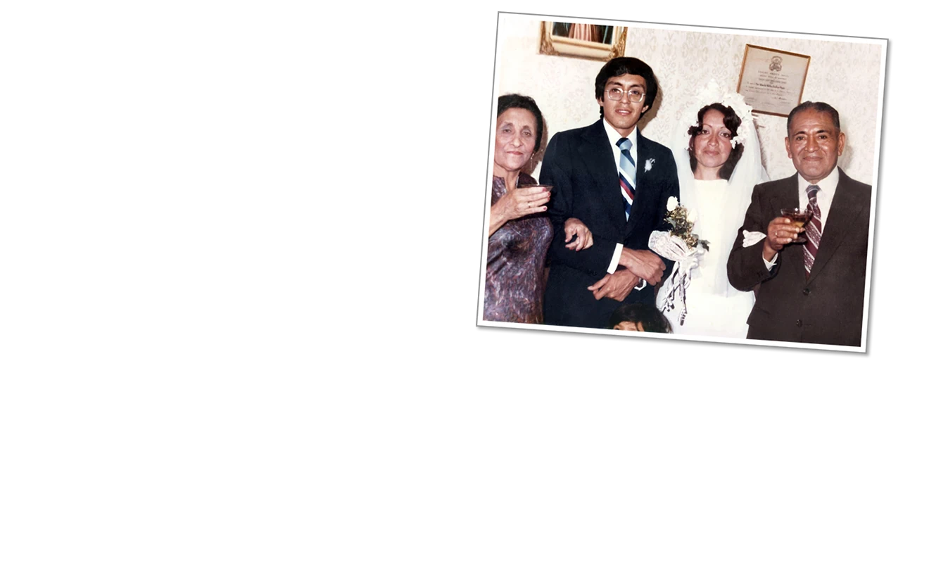 Una foto resturada a color, mostrando a una pareja en su boda junto a sus familiares